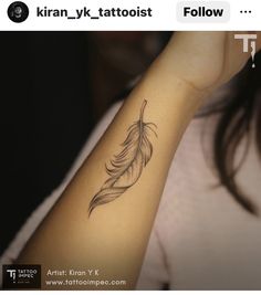 a woman's arm with a feather tattoo on it