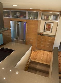 a modern kitchen with stainless steel appliances and wood flooring is seen in this image