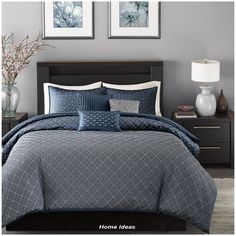 a bed in a bedroom with blue comforter and pillows