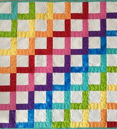 a multicolored quilt is displayed on the wall