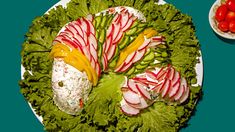 a white plate topped with lettuce covered in candy canes next to a bowl of tomatoes