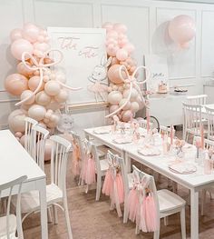 a room filled with tables and chairs covered in balloons