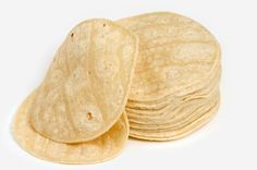 several tortilla shells stacked on top of each other in front of a white background