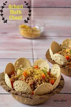 two bowls filled with taco salad and tortilla chips on top of a wooden table