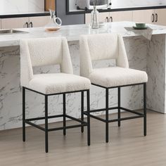 two white chairs sitting on top of a kitchen counter