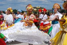 several women in colorful costumes are dancing on the street