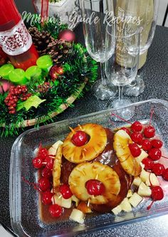 pineapples, cherries and bananas are arranged on a tray next to champagne glasses