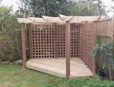 a wooden gazebo sitting in the middle of a yard