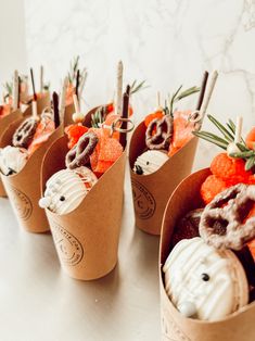 small cupcakes in brown paper cups decorated with orange and white frosted decorations