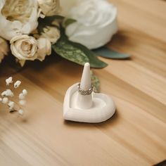 a wedding ring sits on a table next to flowers