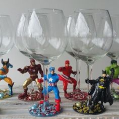 several wine glasses and figurines are sitting on a table