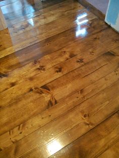 the wood floor is shiny and brown in color