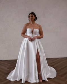 a woman in a white dress standing on a wooden floor with her legs spread out