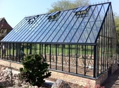 a large glass house sitting on top of a lush green field