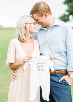 a man and woman standing next to each other holding a shirt