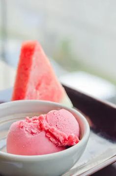 watermelon ice cream in a bowl next to a slice of watermelon