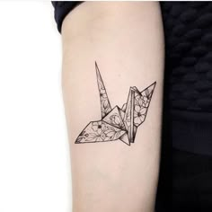 an origami bird tattoo on the arm