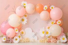 an arrangement of balloons and daisies in front of a pink backdrop with white daisies