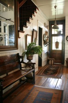 a wooden bench sitting on top of a hard wood floor next to a door and window