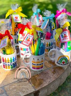 several coffee mugs filled with colored crayons and pencils on a table