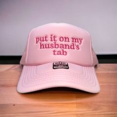 "Put it on my husband's tab" on your favorite color Otto Foam High-Profile Trucker Hat. How to Order: 1. Choose the color hat  2. Pick the color of thread   The saying can be customized. Message us before ordering with your request or any questions. Hat Description:  The Traditional Look 5-panel cap Seamless Foam Front Panel with Lining Matching Color Braid Visor Matching Fabric Undervisor, Adjustable Snapback SHAPE: High-Profile FABRIC:  100% Polyester Front,  Mesh Back VISOR: Pre-curved FIT & Wedding Snapback Trucker Hat, Adjustable Trucker Hat For Wedding, Cute Pink Wedding Hat, Funny White Hat For Gift, Funny White Hat As Gift, Funny White Hat As A Gift, Custom Adjustable Wedding Hats, Customizable Funny Adjustable Hat, Adjustable Funny Customizable Hats