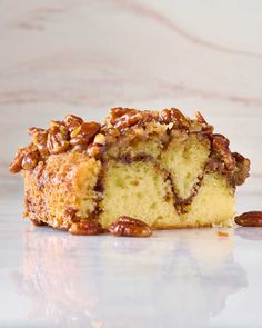 a close up of a piece of cake with pecans on the side and one slice missing