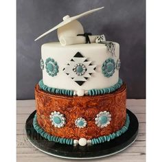 a three tiered cake decorated with turquoise and white decorations