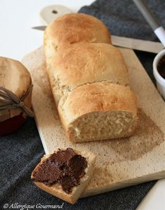 a loaf of bread sitting on top of a cutting board next to a cup of coffee