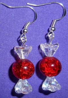 pair of red and clear glass earrings on purple background