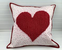 a red and white pillow with a heart on it