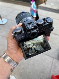 a person holding up a camera on the street