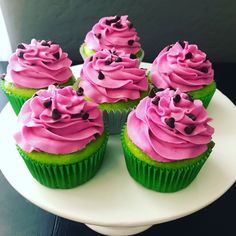 cupcakes with pink frosting and sprinkles on a white plate