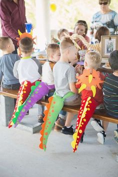 children are sitting at a table with kites in front of them