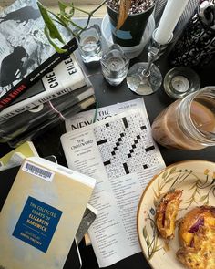 a table topped with books and food next to a vase filled with flowers on top of it