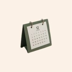 a desk calendar with the date 12 on it is hanging from a clipping holder