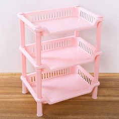 a pink plastic shelf with three baskets on it