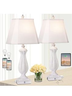 two lamps sitting on top of a table next to a vase with flowers in it