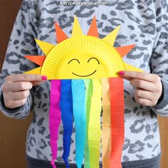 a person holding a paper plate with a sun on it