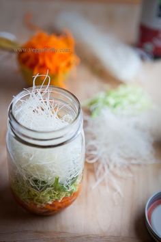 a jar filled with food sitting on top of a wooden table next to other items