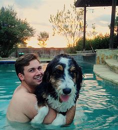 a man and his dog are in the pool