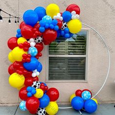 the balloon arch is decorated with soccer balls and streamers in red, white, blue, and yellow