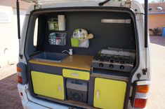 the back end of a van with a stove and sink