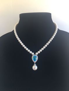 Classic aqua blue cubic zirconia teardrop and pearls bridal necklace in rhodium plated brass setting.  This gorgeous necklace features a large teardrop pendant with pear cut aqua blue cubic zirconia center surrounded by tiny round zirconia crystals with a dangling 12mm Austrian crystal pearl drop. This pendant is strung in a row of 6mm Austrian crystal pearls. Length of the necklace is 16 inches and comes with 2 inches adjustable extender and closed with a lobster clasp. Necklace is also availab Blue Pearl Drop Necklaces For Wedding, Blue Pearl Drop Necklace For Wedding, Formal Blue Pearl Drop Necklace, Blue Pearl Pendant Jewelry For Wedding, Bridal Backdrop, Aqua Blue Wedding, Bridal Backdrops, Bridal Pearl Necklace, Pearl Jewelry Wedding