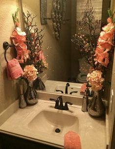 a bathroom sink with two vases and flowers on it