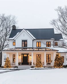 a large white house with christmas lights on the windows