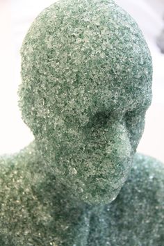 a close up view of a statue made out of green material and glittery fabric