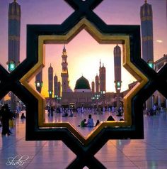 the reflection of a mosque in a window at dusk, with people sitting and walking around