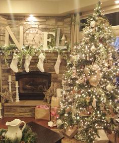 a living room decorated for christmas with stockings on the fireplace