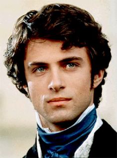 a close up of a person wearing a suit and tie with a serious look on his face