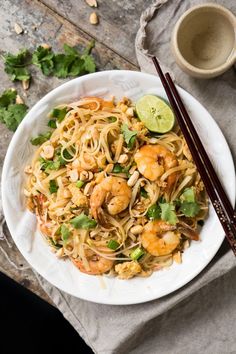 two white plates filled with noodles and shrimp